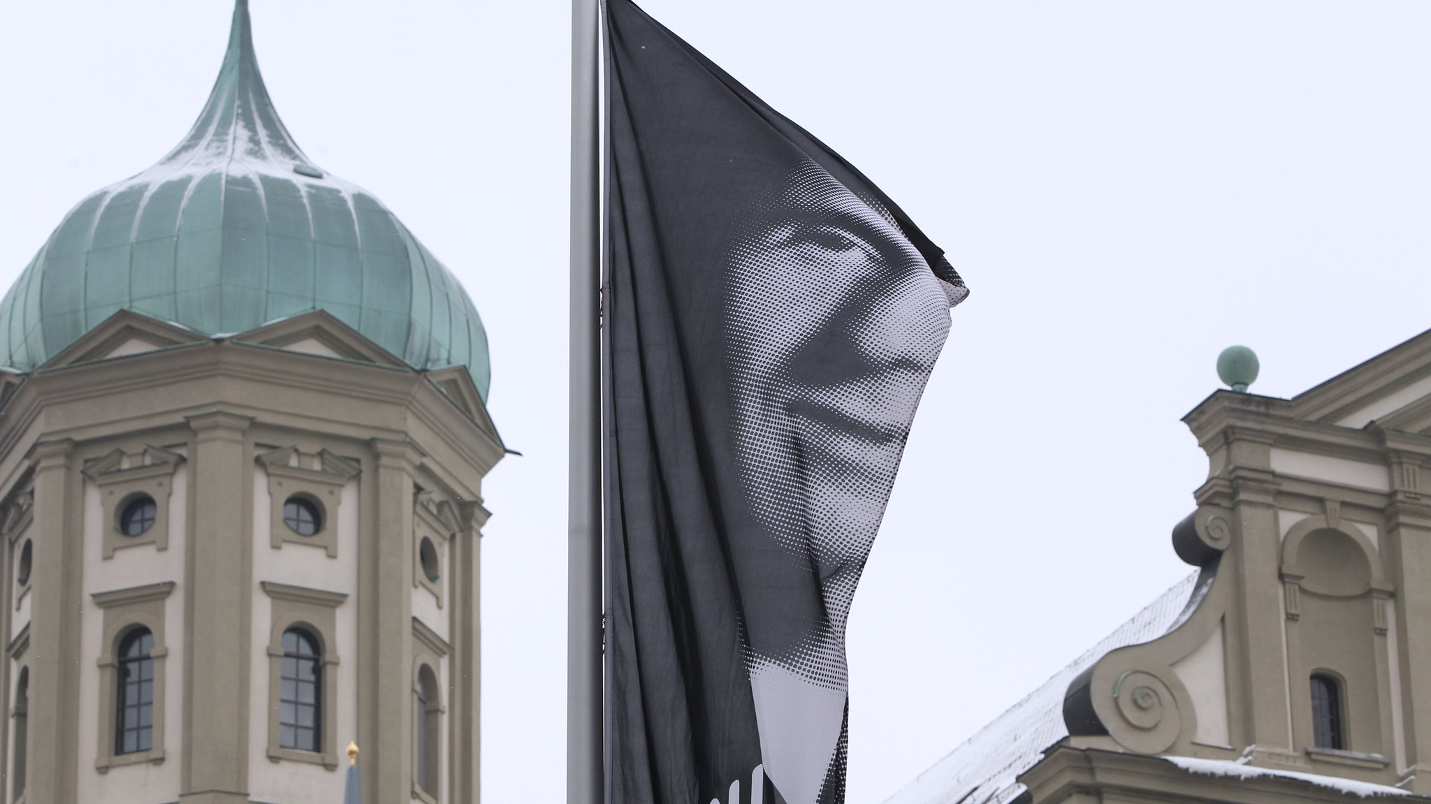 Eine Fahne wirbt vor dem Rathaus in Augsburg mit dem Portrait Bertolt Brechts für das Brechtfestival 2013. (Archivbild)