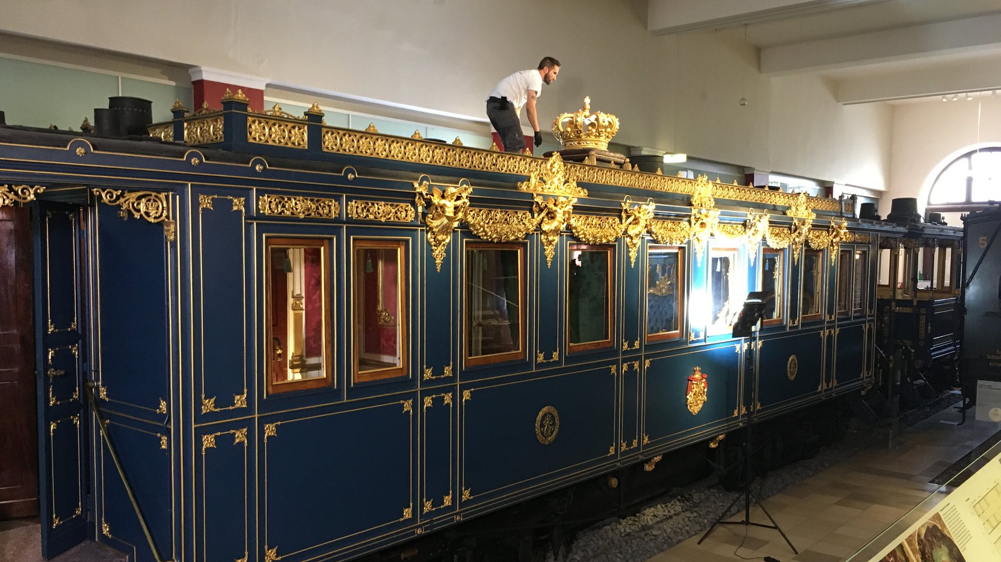 Ein Mann steht auf einem vergoldeten Luxus-Waggon von König Ludwig II.