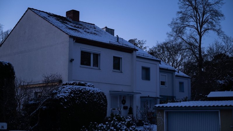 Vier Reihenhäuser in Berlin. In allen Häusern ist das Licht aus, weil der Strom ausgefallen ist. Abenddämmerung hat eingesetzt. Die Natur ist winterlich, Büsche mit Schnee bedeckt. | Bild: dpa-Bildfunk/Christophe Gateau Vier Reihenhäuser in Berlin. In allen Häusern ist das Licht aus, weil der Strom ausgefallen ist. Abenddämmerung hat eingesetzt. Die Natur ist winterlich, Büsche mit Schnee bedeckt.