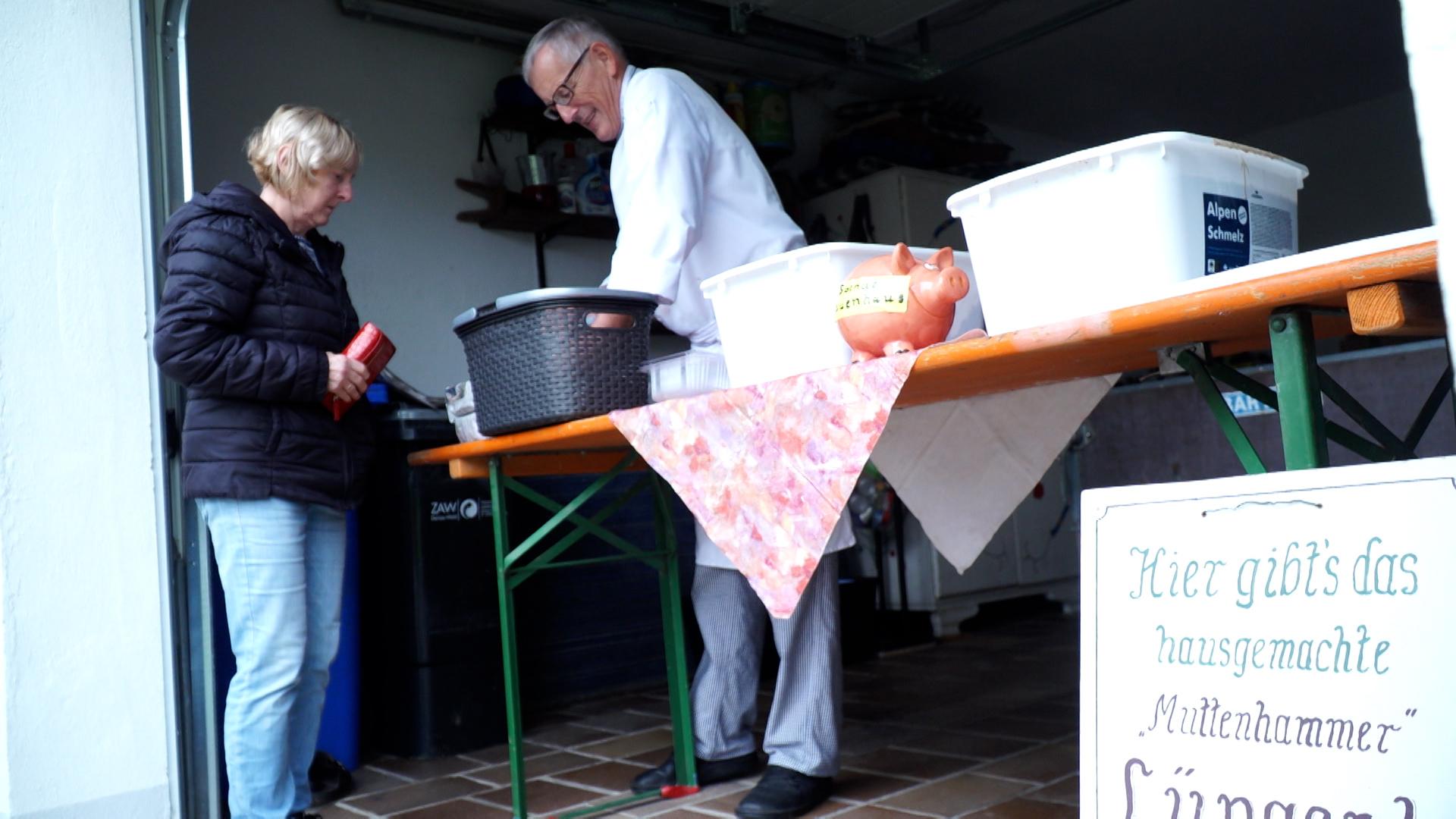 Der Koch verkauft einer Kundin Lüngerl.