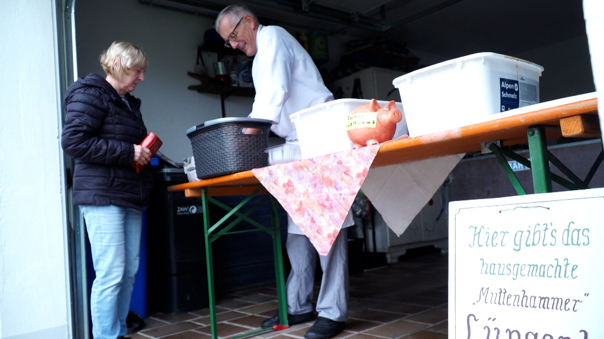 Der Koch verkauft einer Kundin Lüngerl.