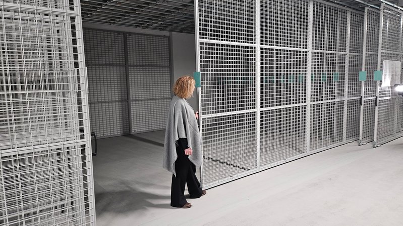 Eine Frau zieht ein Rollgitter auf | Bild: BR/ Nicolas Eberlein Eine Frau zieht ein Rollgitter auf