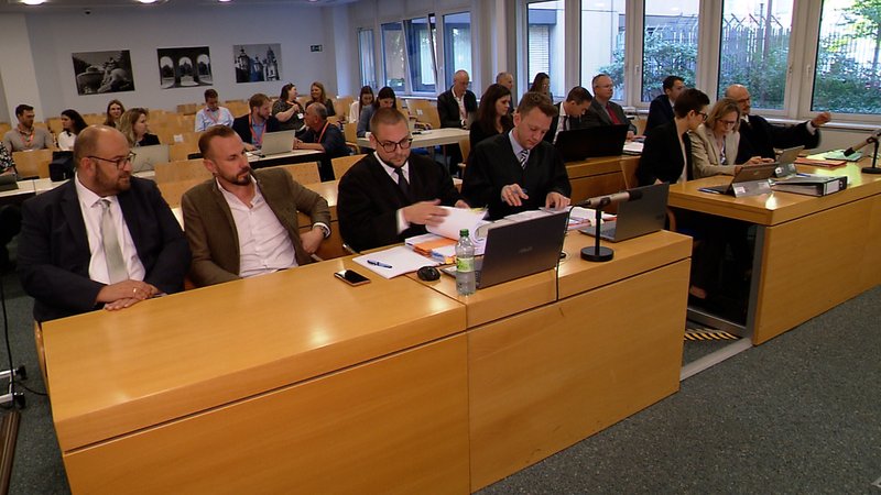 Die Klägerin sitzt auf ihrer Bank im Verwaltungsgericht München. | Bild: Bayerischer Rundfunk Die Klägerin sitzt auf ihrer Bank im Verwaltungsgericht München.