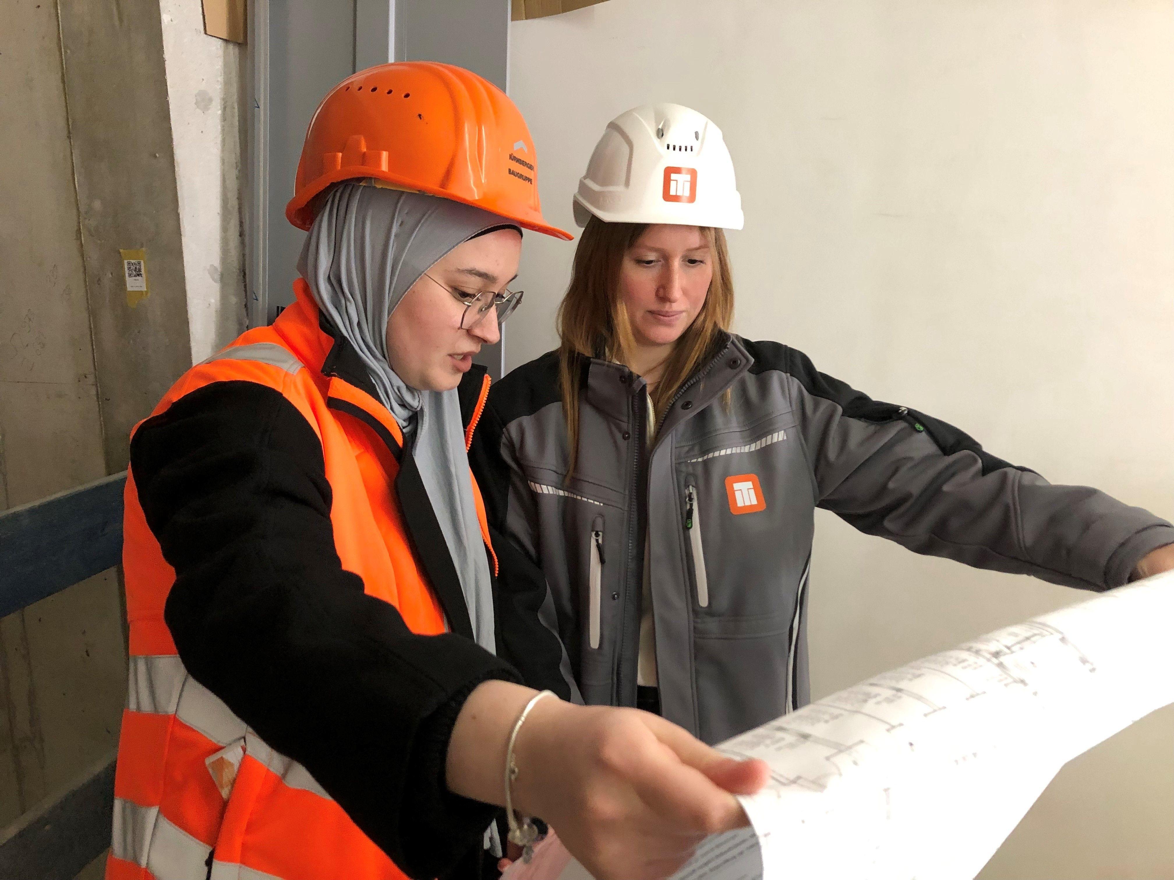 Bauzeichnerin Zehra Duran und Anneke Stößel vom Bauleiter-Team auf einer Baustelle in Nürnberg.