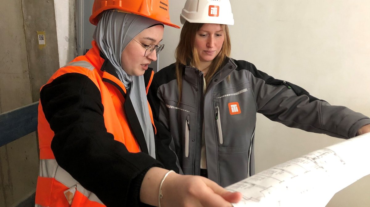 Bauzeichnerin Zehra Duran und Anneke Stößel vom Bauleiter-Team auf einer Baustelle in Nürnberg.