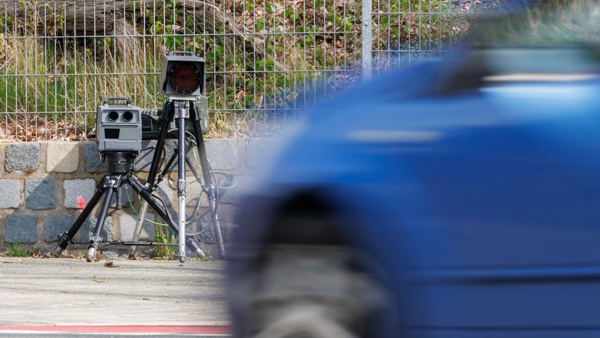 Mobiler Blitzer mit Auto im Vordergrund.