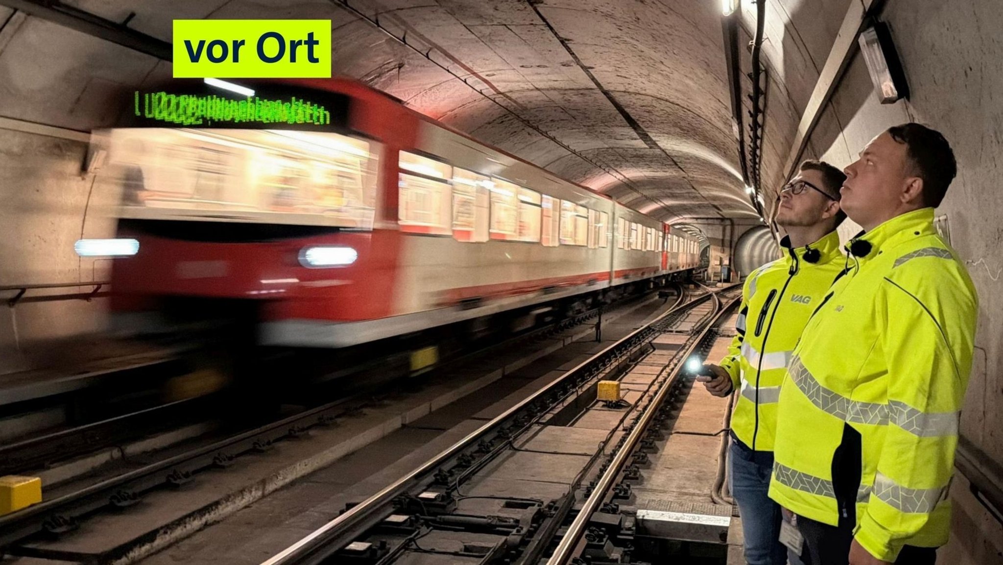 Die Tunnelprüfer Roman Bößl und Thomas Frisch bei der Arbeit, die U-Bahn fährt mit bis zu Tempo 80 vorbei.