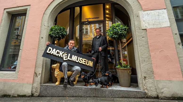 Zwei Männer und drei Hunde posieren in einem Türbogen. | Bild:dpa-Bildfunk/Armin Weigel