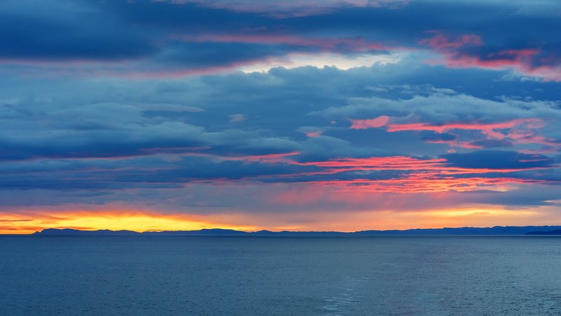 Farbenfroher und bewölkter Sonnenaufgang über dem Europäischen Nordmeer vor Norwegen;  rekordverdächtige Temperaturen im Nordatlantik und ihre globalen Auswirkungen