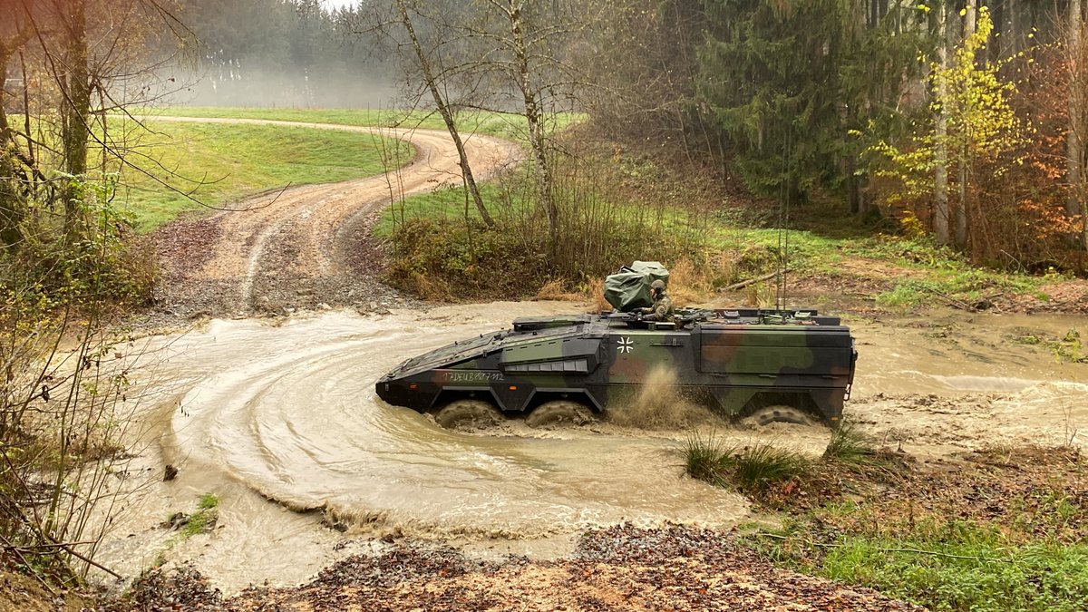 Das Bundeswehrfahrzeug "Boxer" fährt durch ein künstlich angelegtes, drei Meter tiefes Wasserhindernis.