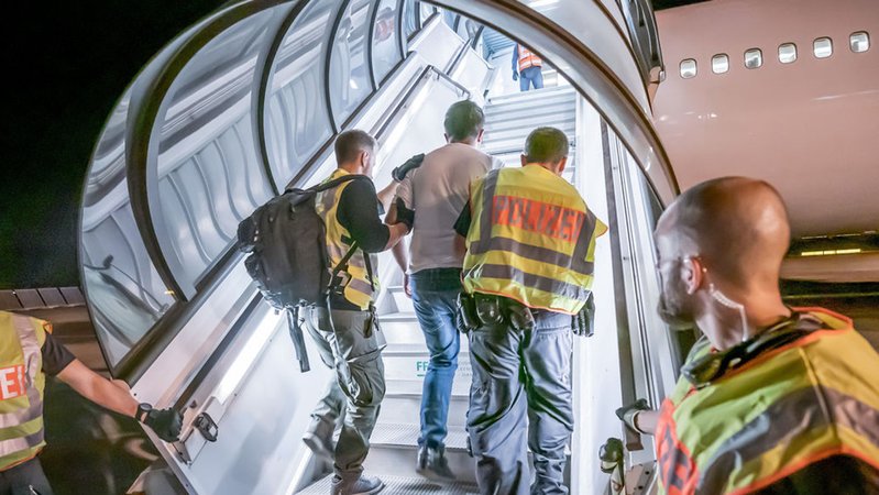 Archivbild: Polizeibeamte begleiten einen Afghanen auf dem Flughafen Leipzig-Halle in ein Charterflugzeug. | Bild: dpa-Bildfunk/Michael Kappeler Archivbild: Polizeibeamte begleiten einen Afghanen auf dem Flughafen Leipzig-Halle in ein Charterflugzeug.
