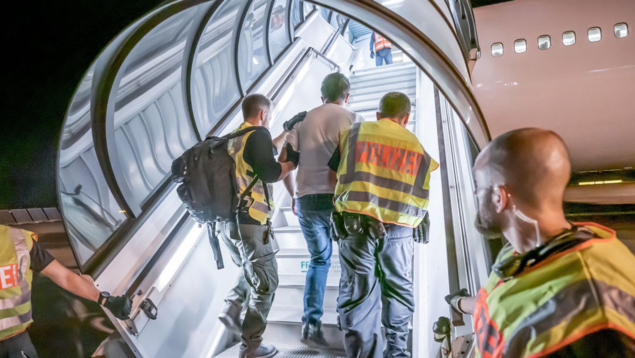 Archivbild: Polizeibeamte begleiten einen Afghanen auf dem Flughafen Leipzig-Halle in ein Charterflugzeug. 