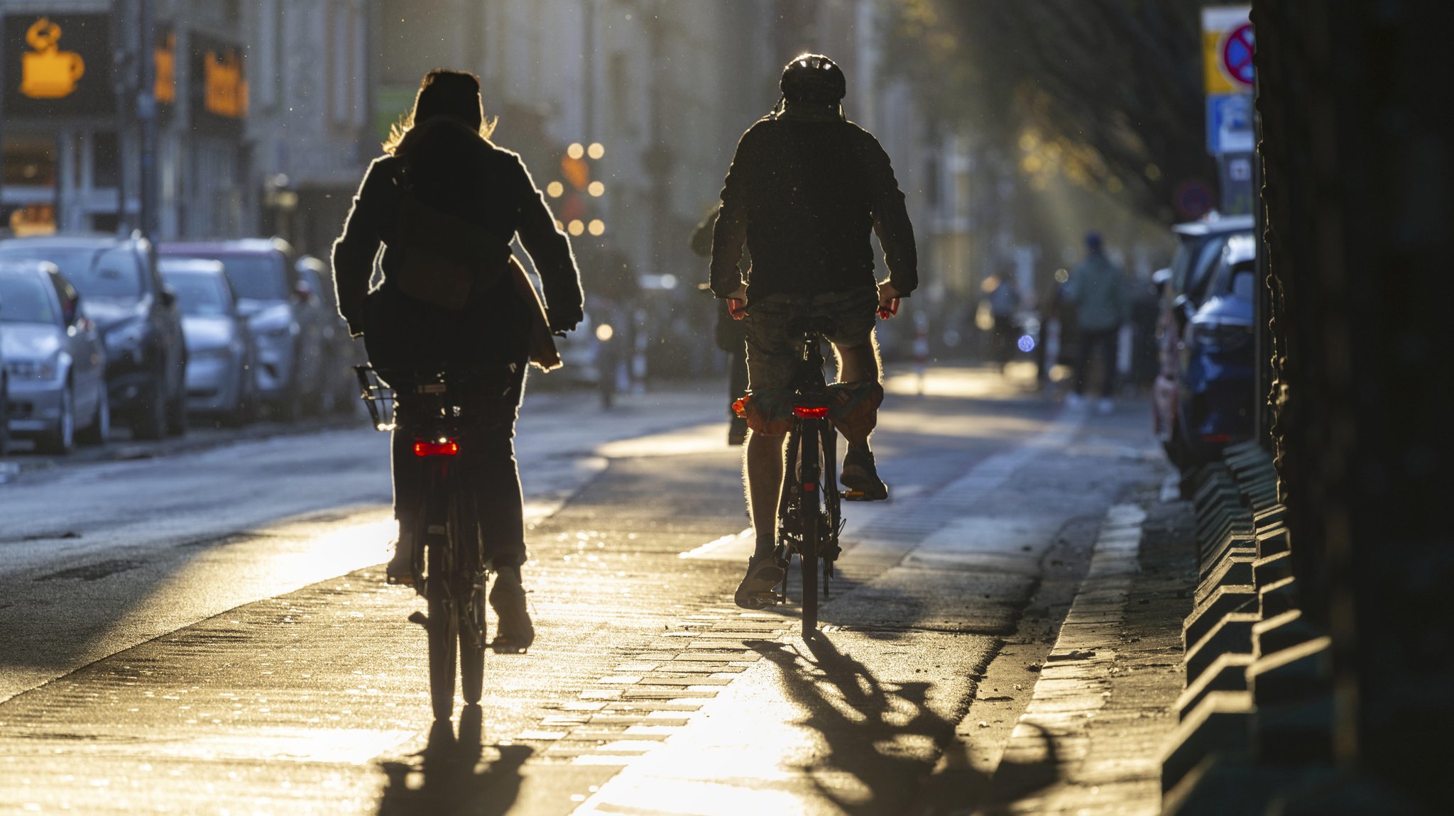 Zwei Radfahrer im Novemberlicht auf einem Radweg