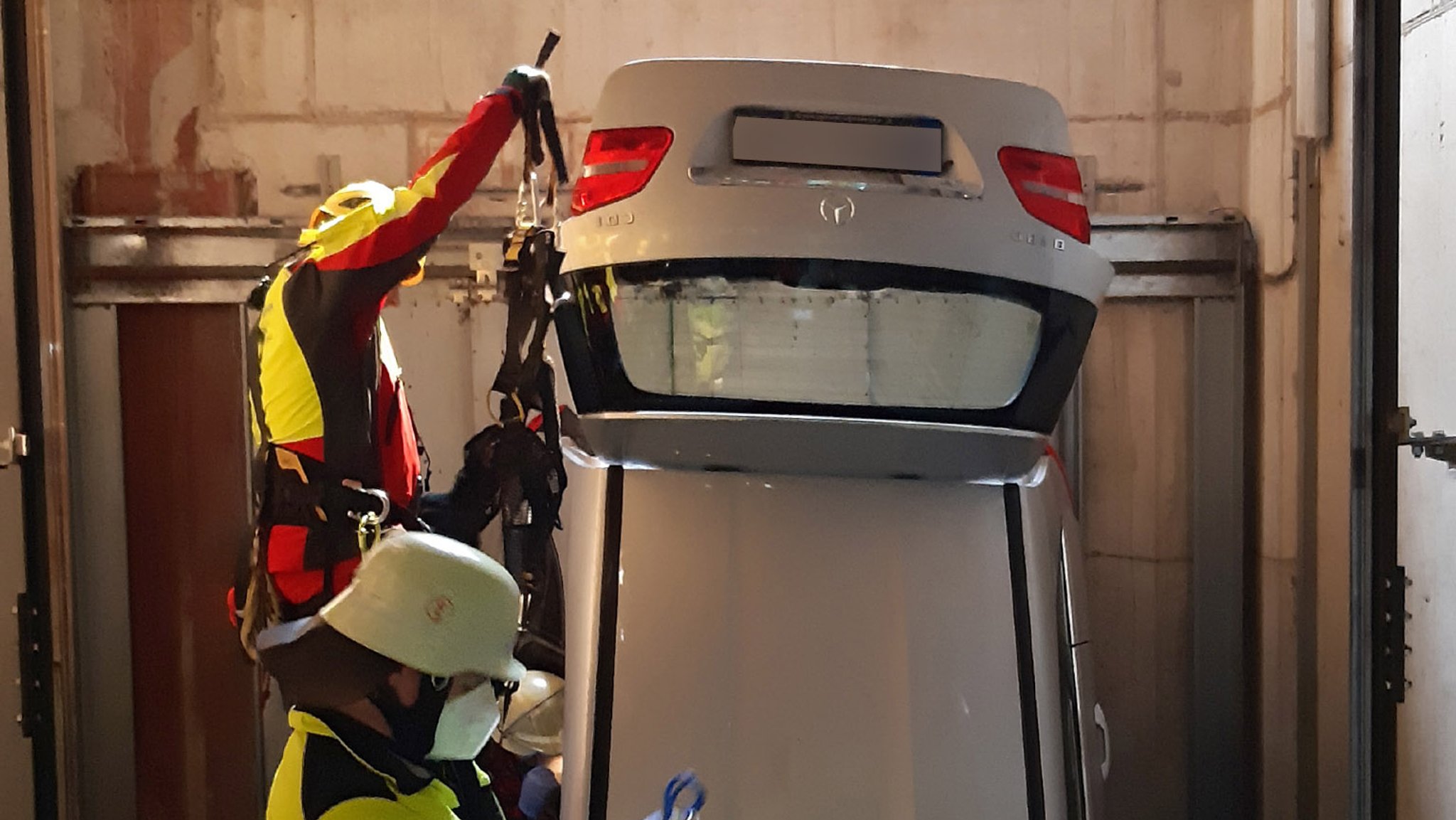 Das Auto liegt – mit dem Heck voraus – im Schacht und wird von der Feuerwehr geborgen