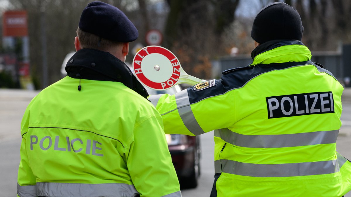 Archivbild: Ein Polizist aus Tschechien (l) und ein Bundespolizist winken ein Auto zu Kontrolle heraus.