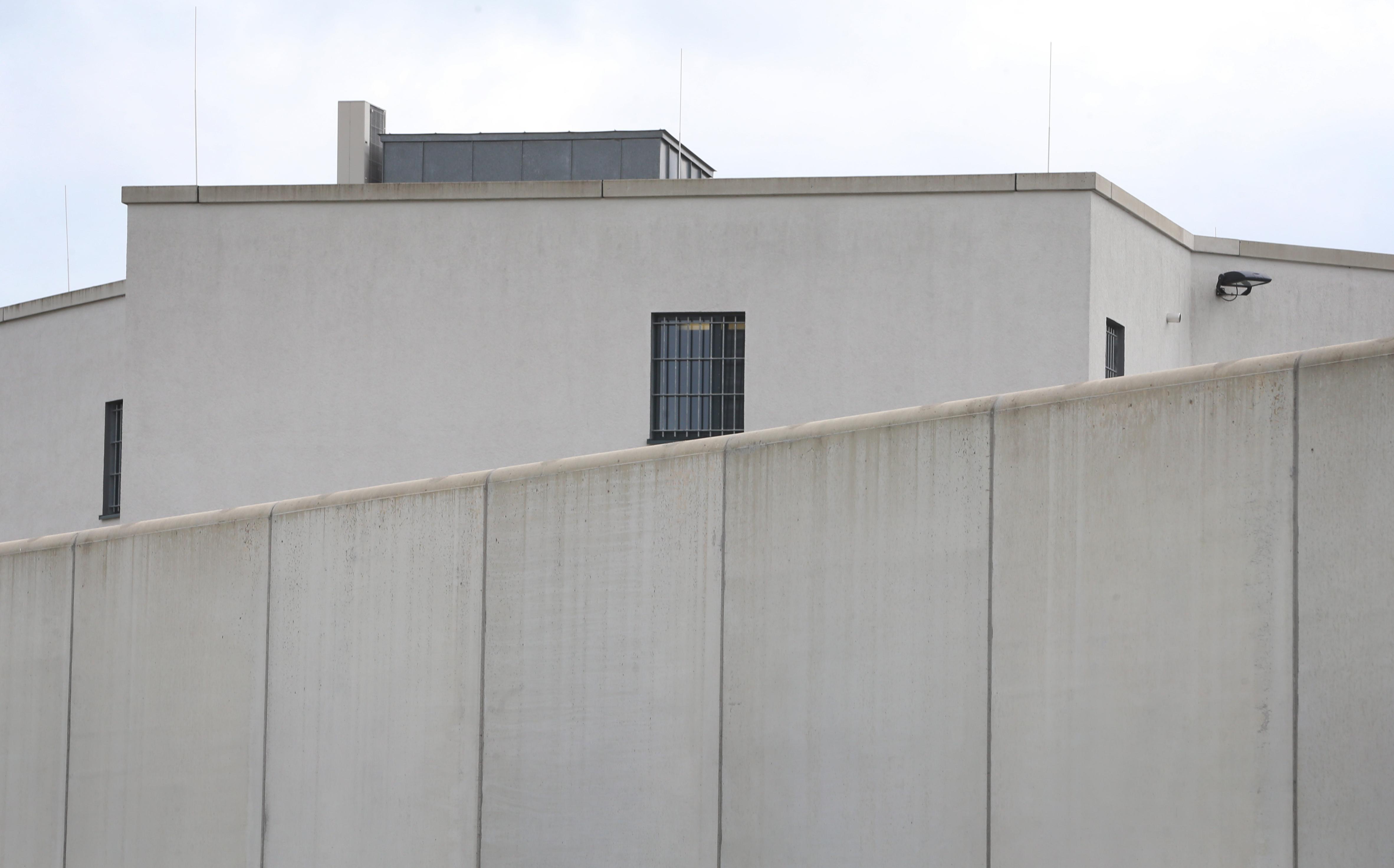 Vergitterte Fenster sind hinter einer Mauer der Justizvollzugsanstalt Gablingen zu sehen.