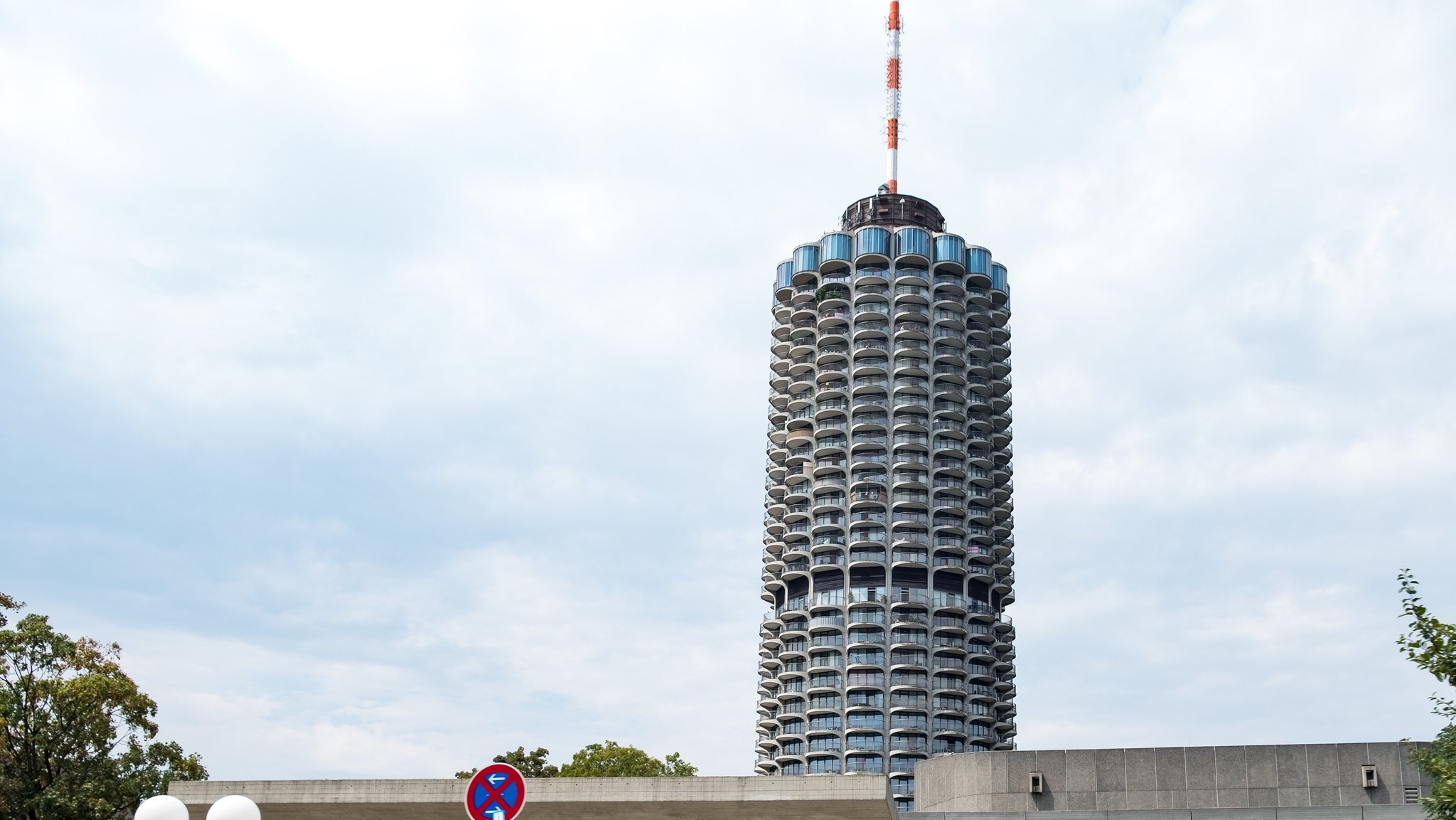 Der Hotelturm Augsburg: ein zylinderförmiges Gebäude, umlaufend besetzt mit halbrunden Balkonen.