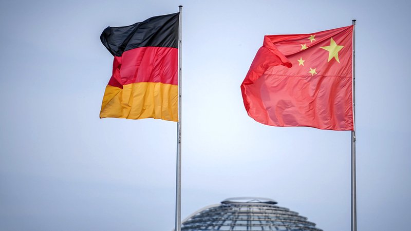 Die Flaggen von Deutschland und China wehen zum Auftakt des Deutschland-Besuchs der chinesischen Regierung vor dem Bundeskanzleramt, im Hintergrund die Kuppel des Reichstagsgebäudes.
