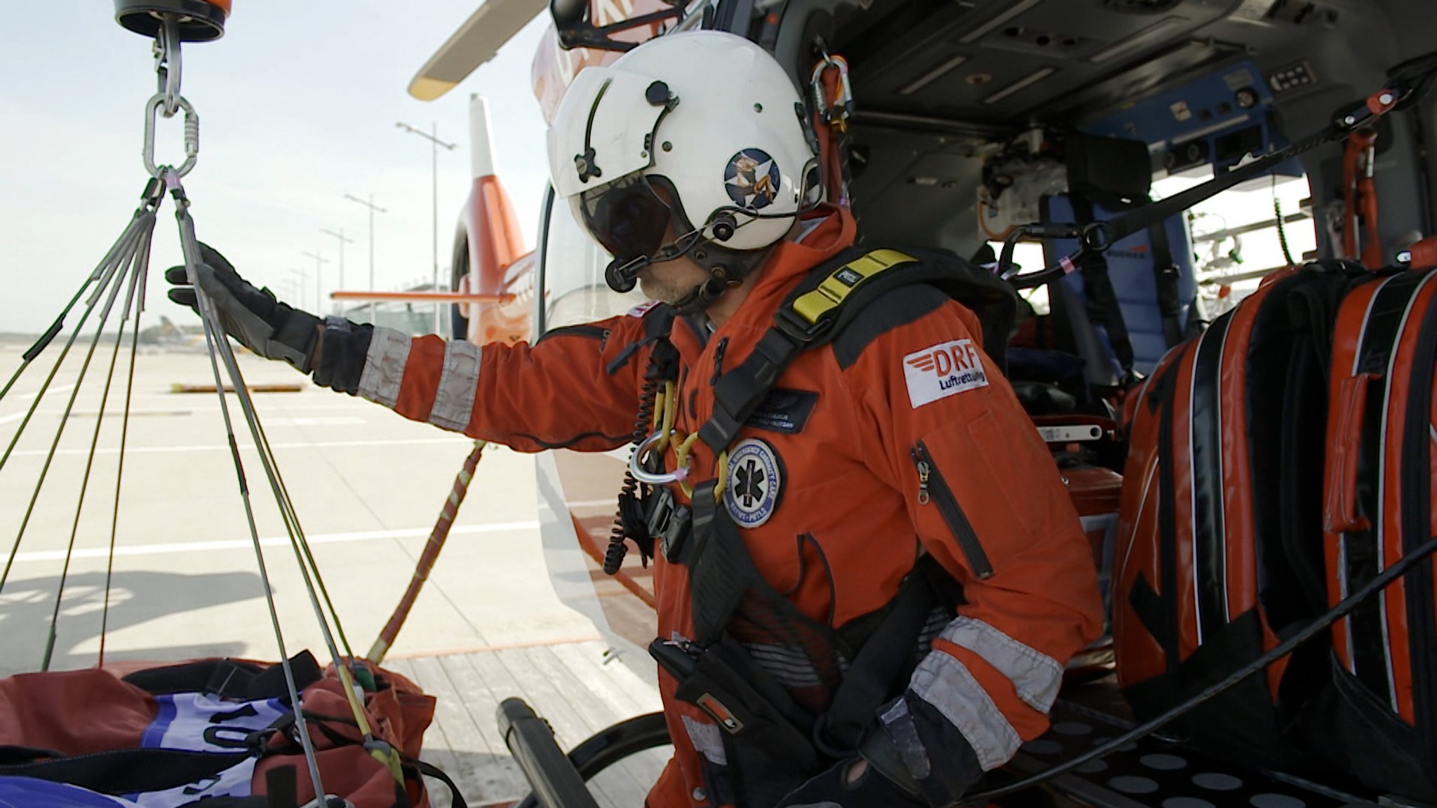 Ein Sanitäter demonstriert den Seilzug des neuen Helikopters.