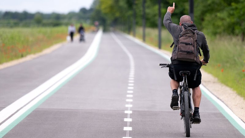 Ein Mann fährt mit einem Fahrrad bei einem Pressetermin über die Radschnellverbindung zwischen München und Garching. 