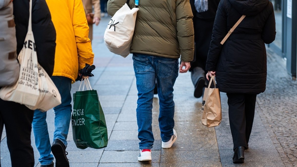 Menschen tragen verschiedene Einkaufstüten (Symbolbild).