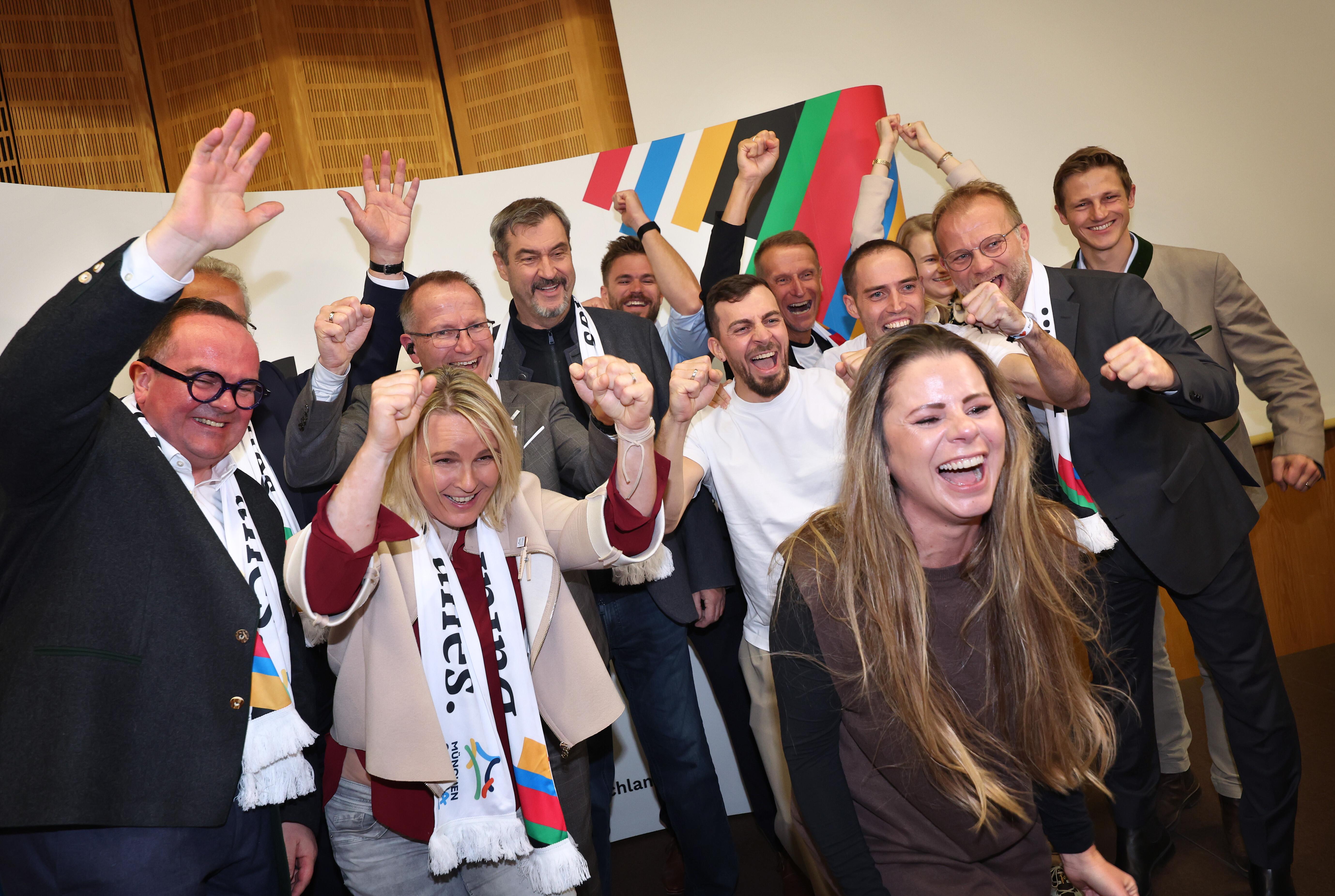 Markus Söder (CSU, 4.v.l), Ministerpräsident von Bayern, jubelt zusammen mit Sportlern, Politikern und Funktionären nach der Bekanntgabe der ersten Hochrechnungen zum Ergebnis des Bürgerentscheids zur Olympia-Bewerbung im Haus des Sports.