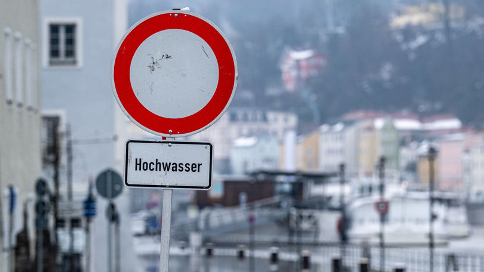 Ein Hochwasserschild warnt vor einer überschwemmten Straße (Archivbild).