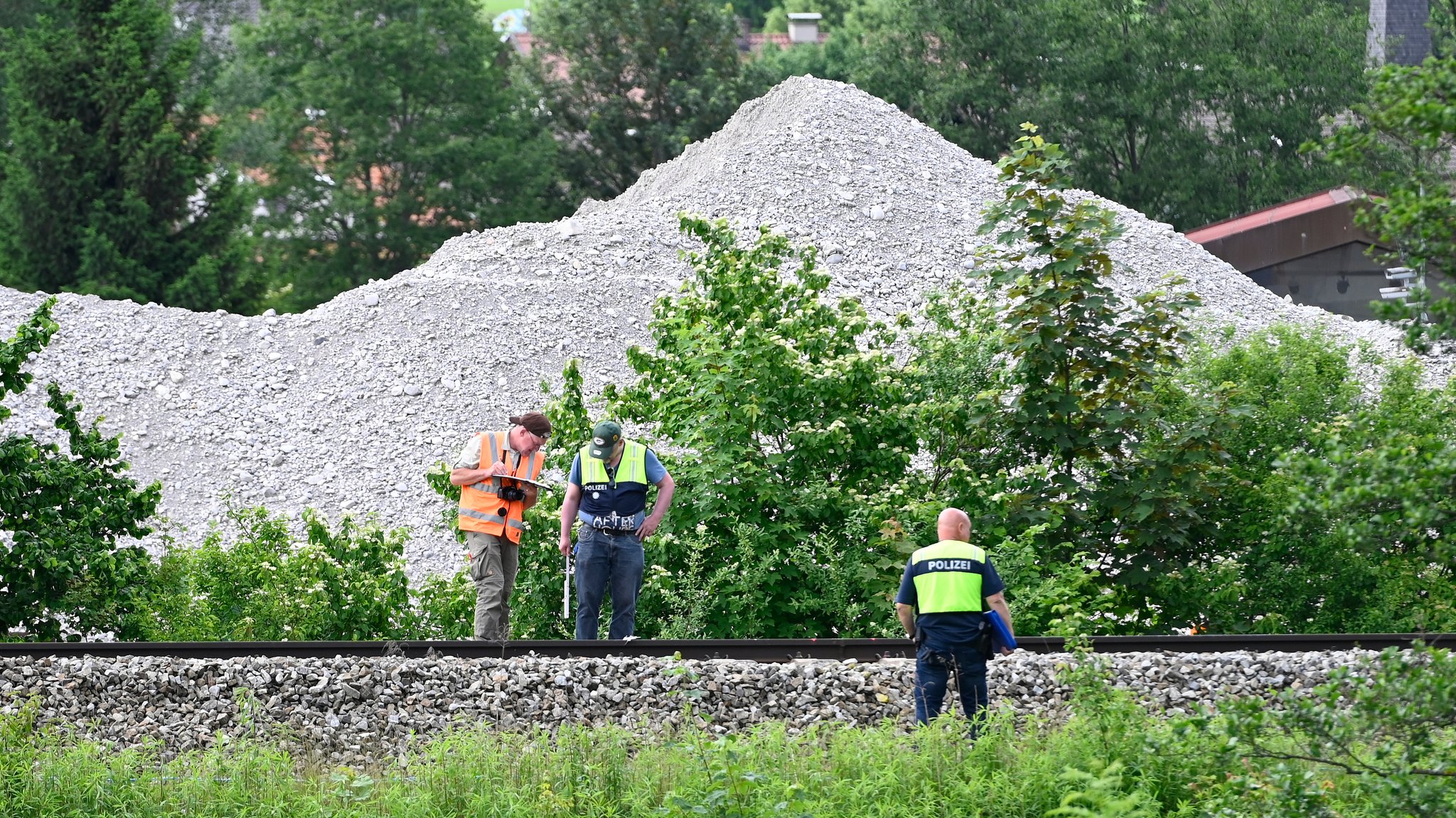 Polizeibeamte untersuchen den Gleisbereich der verunglückten Regionalbahn. 