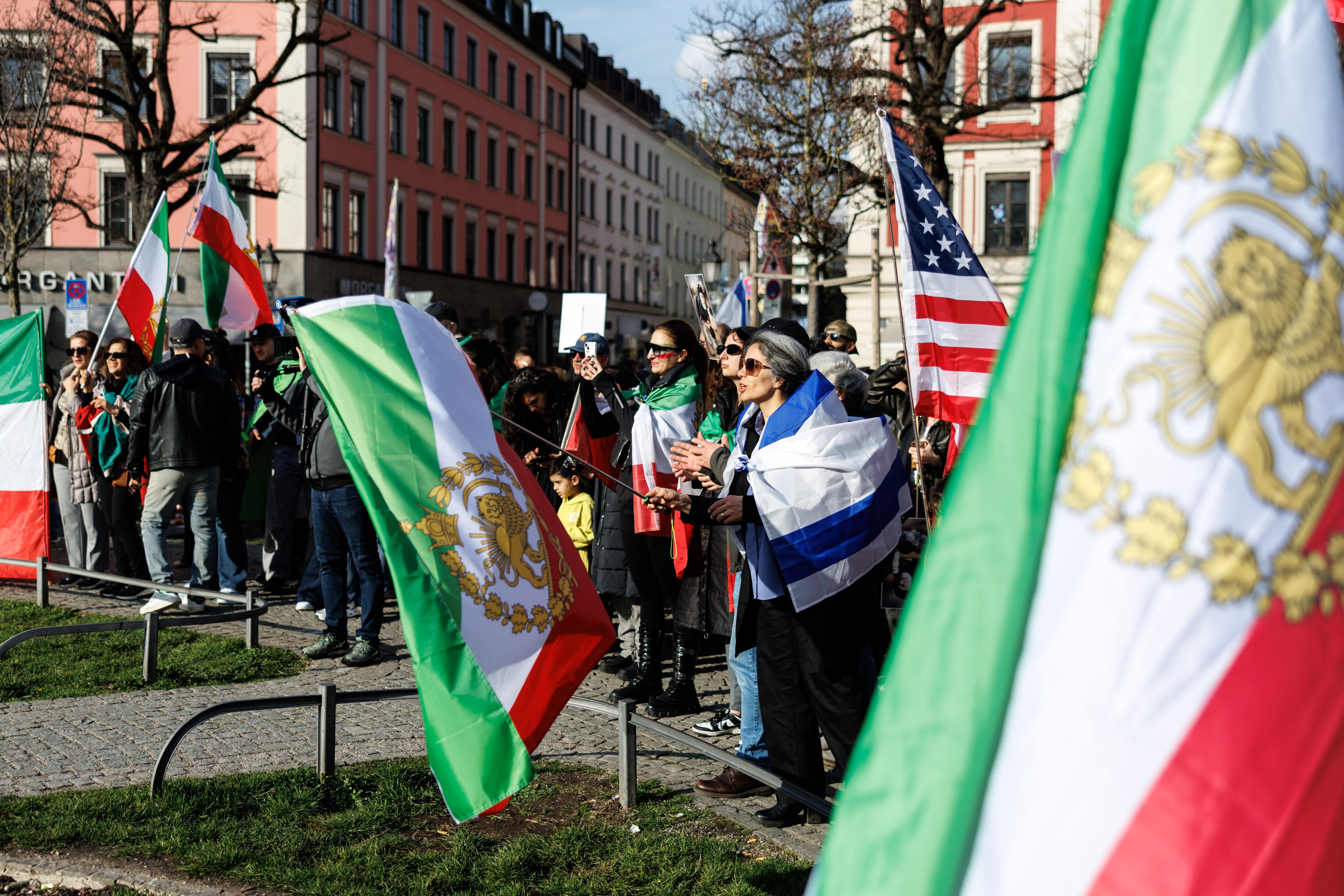 Teilnehmer einer Kundgebung unter dem Motto "Nein zur Islamischen Republik Iran!" mit Flaggen von den USA und vom Iran am Gärtnerplatz
