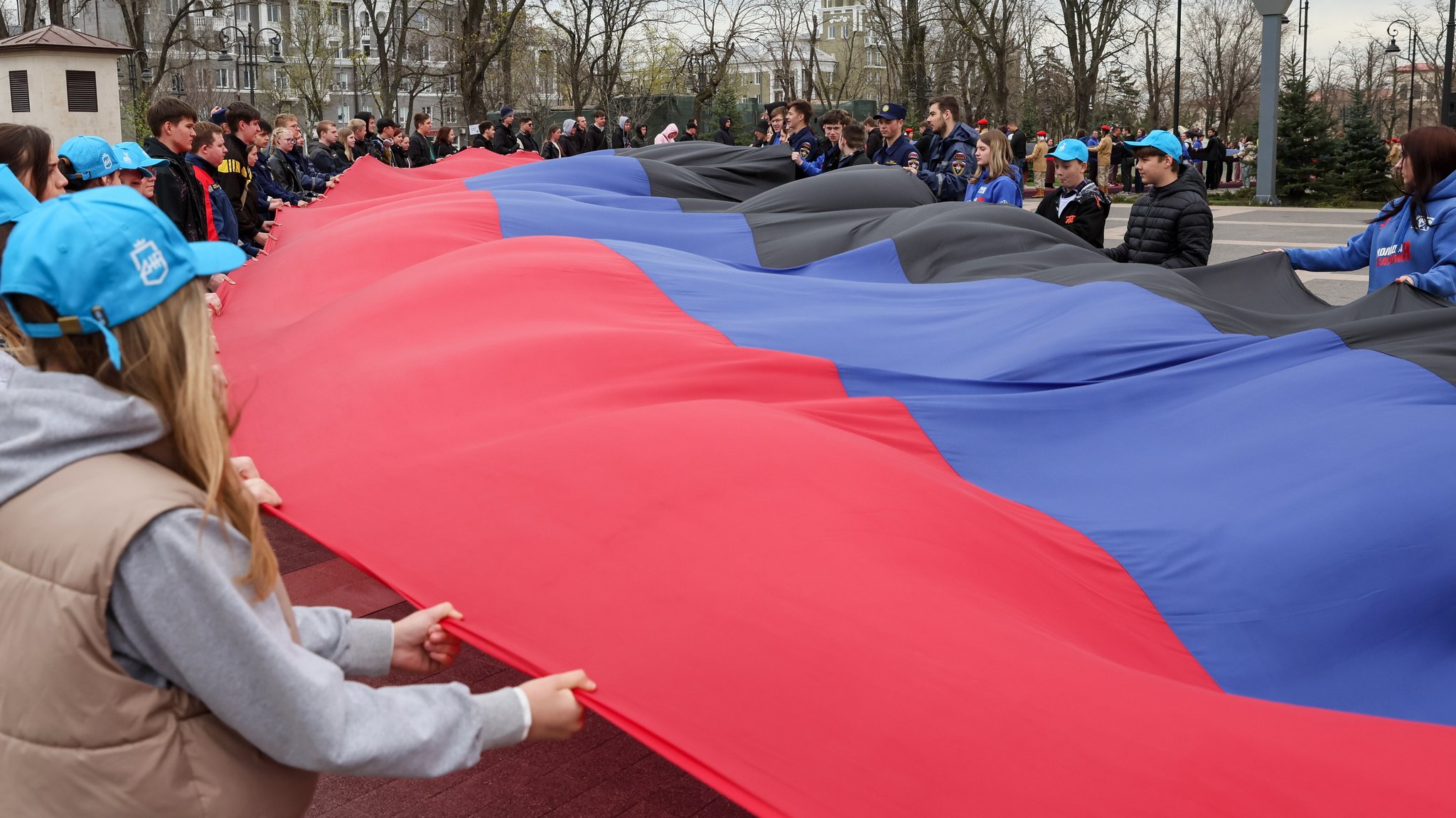 Eine 200 Meter lange russische Nationalflagge wird von Kundgebungsteilnehmern getragen