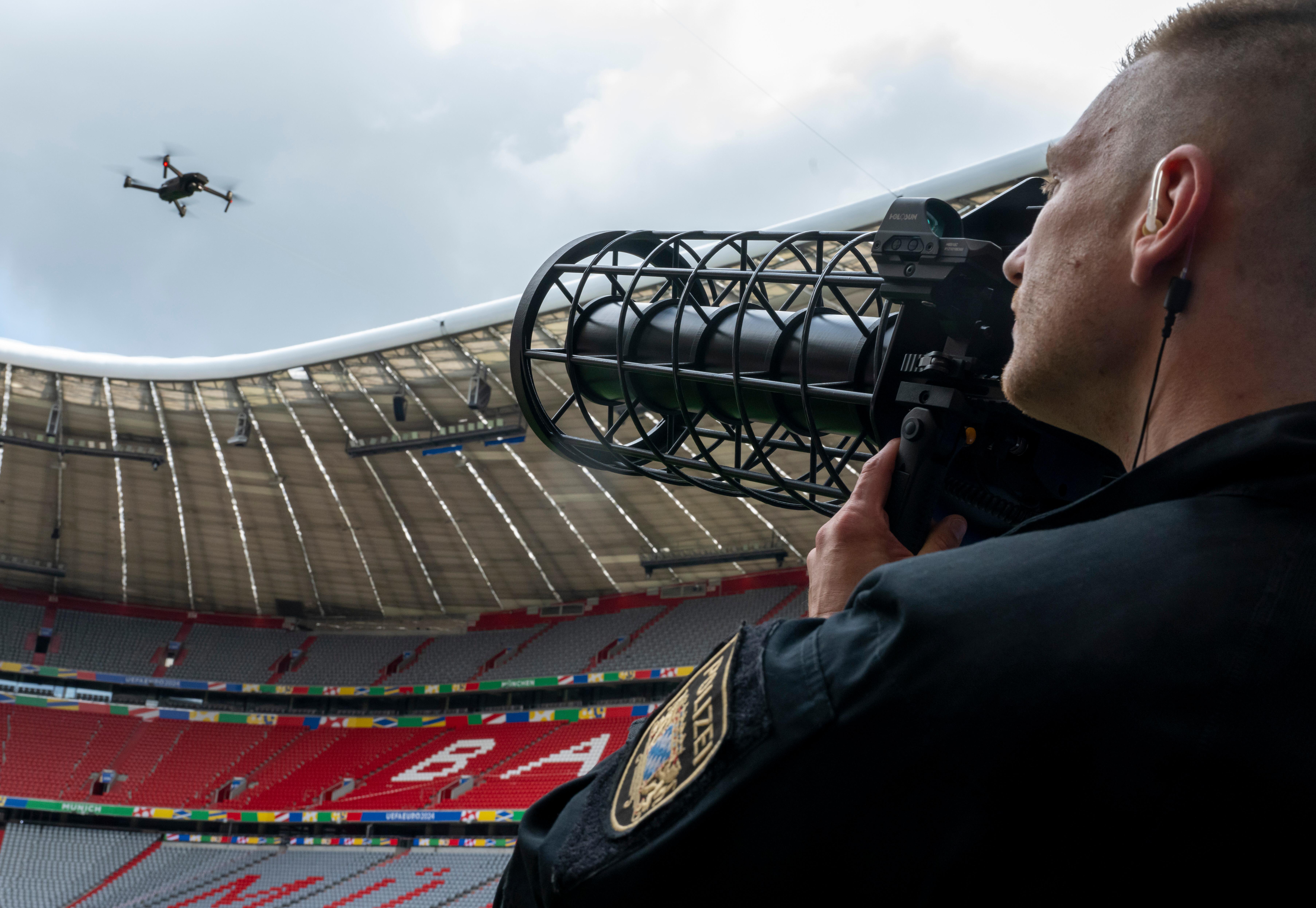 Ein speziell ausgebildeter Polizist zeigt während der Vorstellung des Münchner Sicherheitskonzepts zur Fußball-Europameisterschaft 2024 im Fußballstadion München eine kontrollierte Landung einer Drohne, mittels Drohnen-Jammer.
