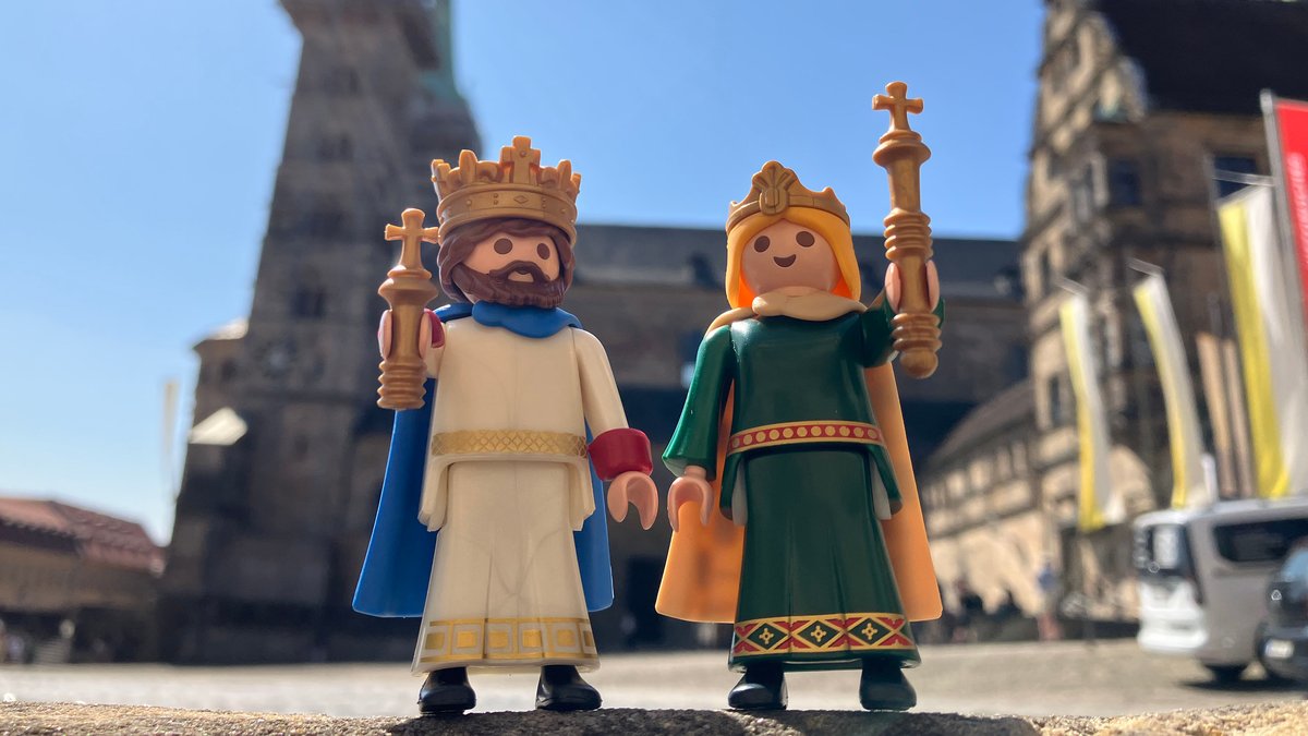 Die Erzbistum-Gründer Kaiser Heinrich und Kaiserin Kunigunde stehen als Playmobil-Figuren vor dem Bamberger Dom.