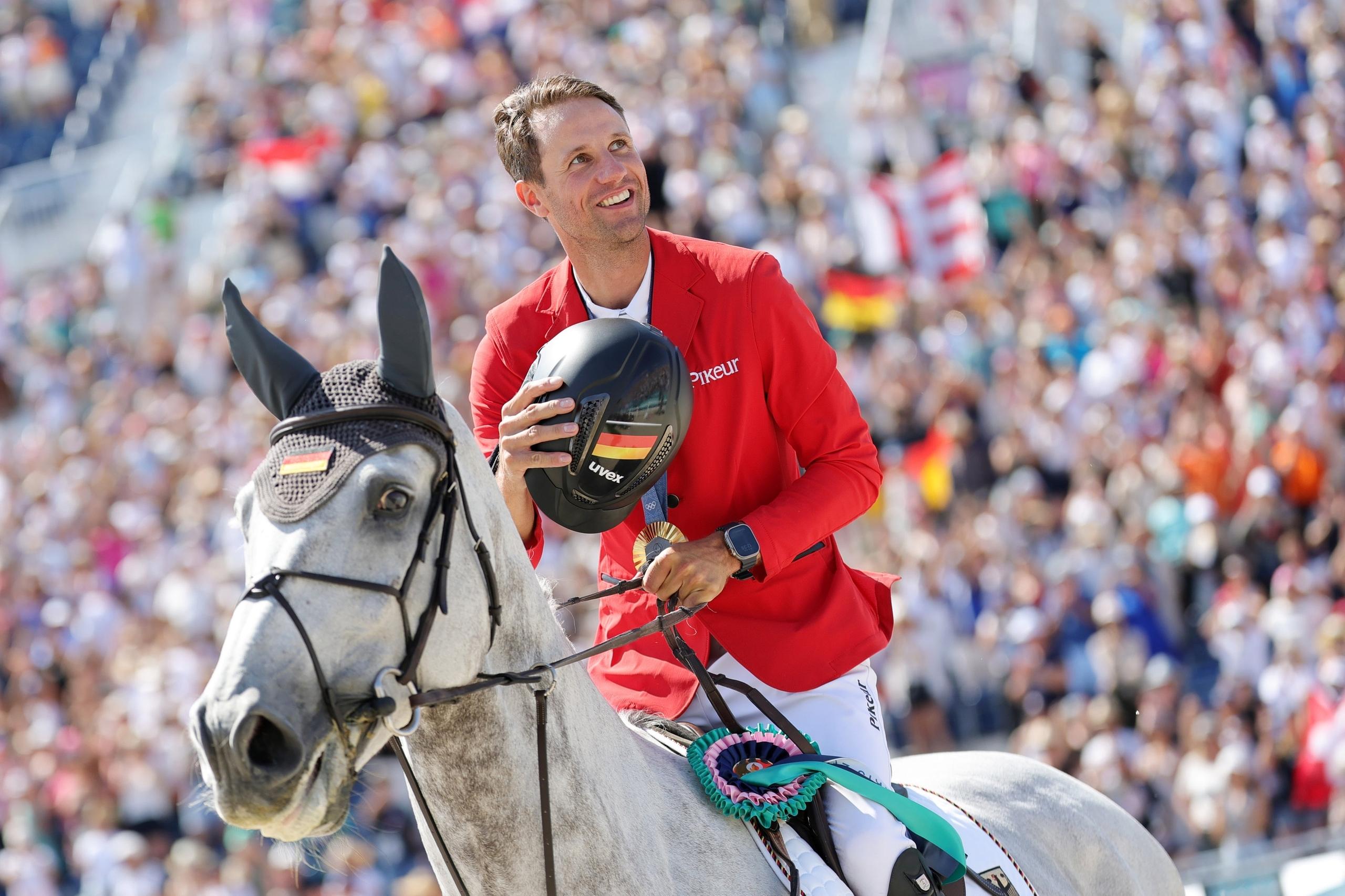 06.08.2024, Frankreich, Paris: Olympia, Paris 2024, Pferdesport, Springen, Einzel, Finale, Deutschlands Christian Kukuk jubelt nach der Siegerehrung über Gold auf Checker 47. Foto: Rolf Vennenbernd/dpa +++ dpa-Bildfunk +++
