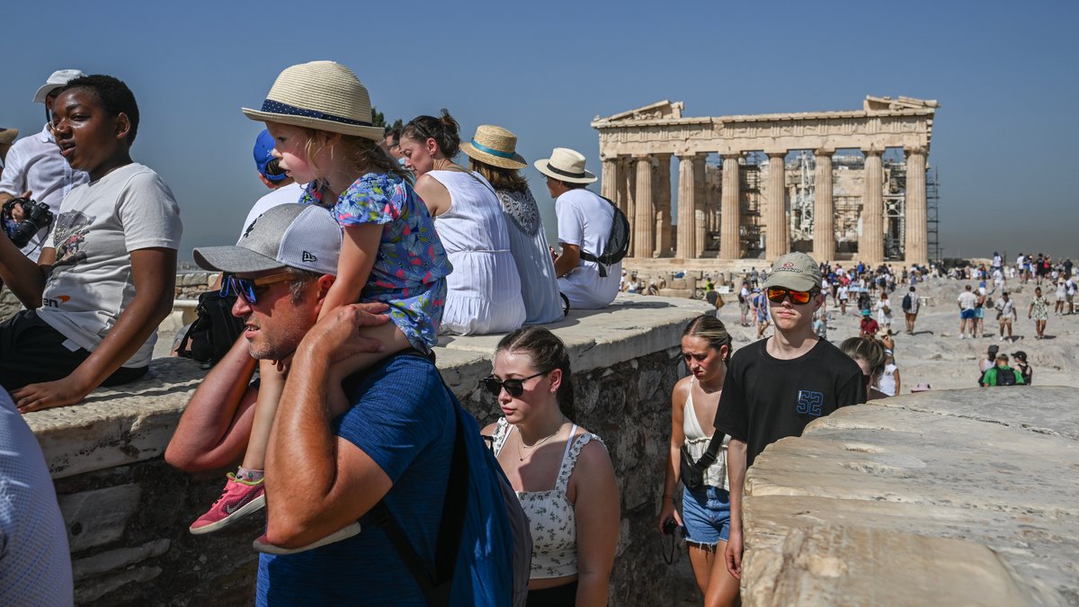 Touristen gehen an einem heißen Tag bei ihrem Besuch des Parthenon-Tempels auf dem Akropolis-Hügel herum. Das Kulturministerium hat beschlossen, die archäologische Stätte während der heißesten Stunden des Tages, von 12 bis 17 Uhr, zu schließen, da Griechenland gerade von einer Hitzewelle betroffen ist. (Archivbild: 14.07.2023)