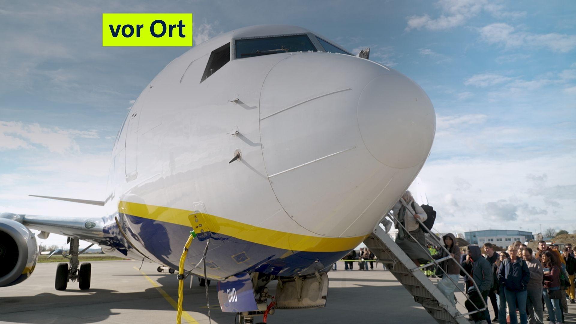 Passagiere an einem Flugzeug auf dem Vorfeld des Memminger Flughafens