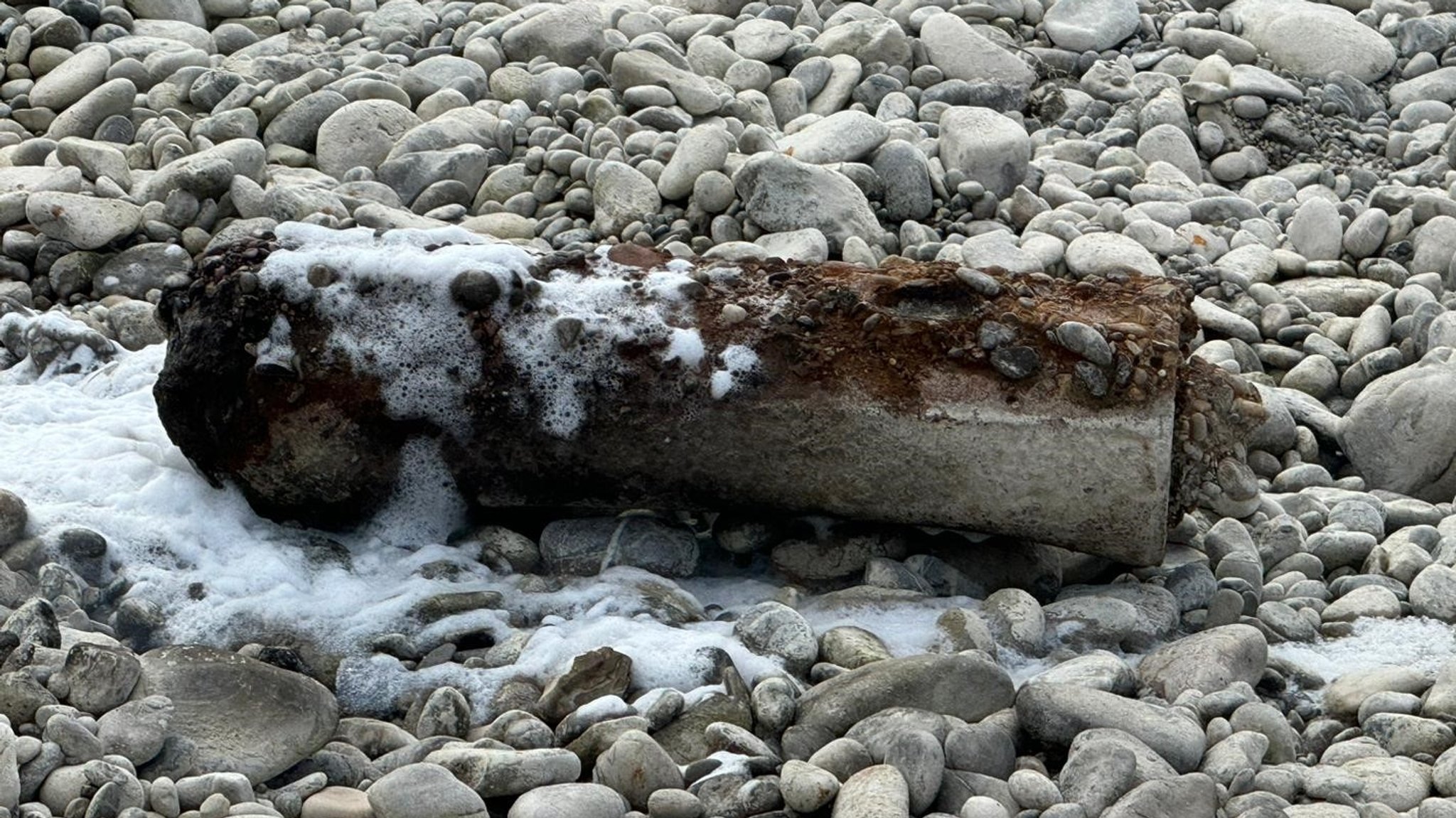 Mit Feuerwehrschaum bedeckte Phosphorbombe liebt auf dem kiesigen Ufer des Lechs in Augsburg