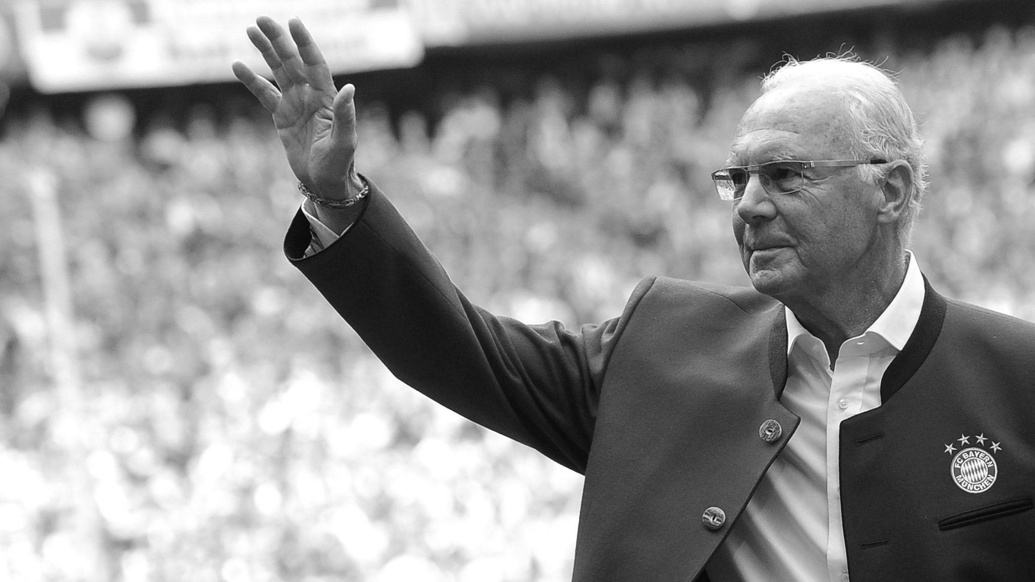 Franz Beckenbauer grüßt die Fußballfans im Stadion. 