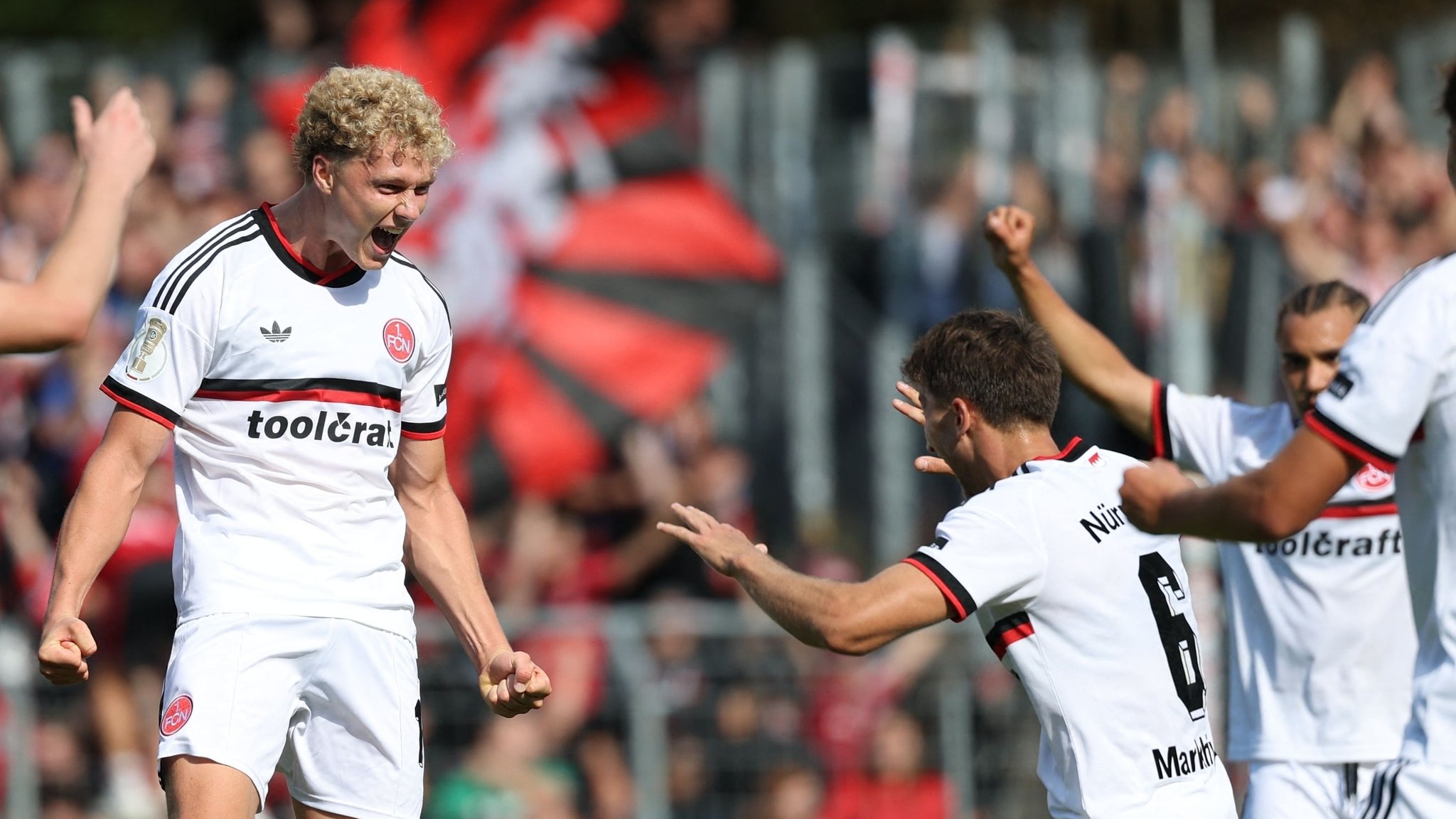 22.08.2026, Nordrhein-Westfalen, Köln: Fußball, Männer: DFB-Pokal, Viktoria Köln - 1. FC Nürnberg, 1. Runde, Sportanlage Höhenberg. Tor zum 0:1 durch 1. FC Nürnbergs Piet Scobel (M). Foto: Fabian Strauch/dpa - WICHTIGER HINWEIS: Gemäß den Vorgaben der Bundesliga bzw. des DFB Deutscher Fußball-Bund ist es untersagt, in dem Stadion und/oder vom Spiel angefertigte Fotoaufnahmen in Form von Sequenzbildern und/oder videoähnlichen Fotostrecken zu verwerten bzw. verwerten zu lassen. +++ dpa-Bildfunk +++