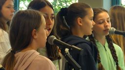 Schülerinnen singen in Mikrofone. | Bild:BR/Vera Held