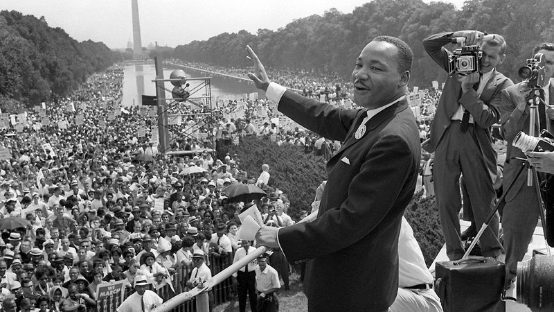 Der US-Bürgerrechtler Martin Luther King winkt bei einer Kundgebung von der Lincoln-Gedächtnisstätte in Washington aus seinen Anhängern zu (