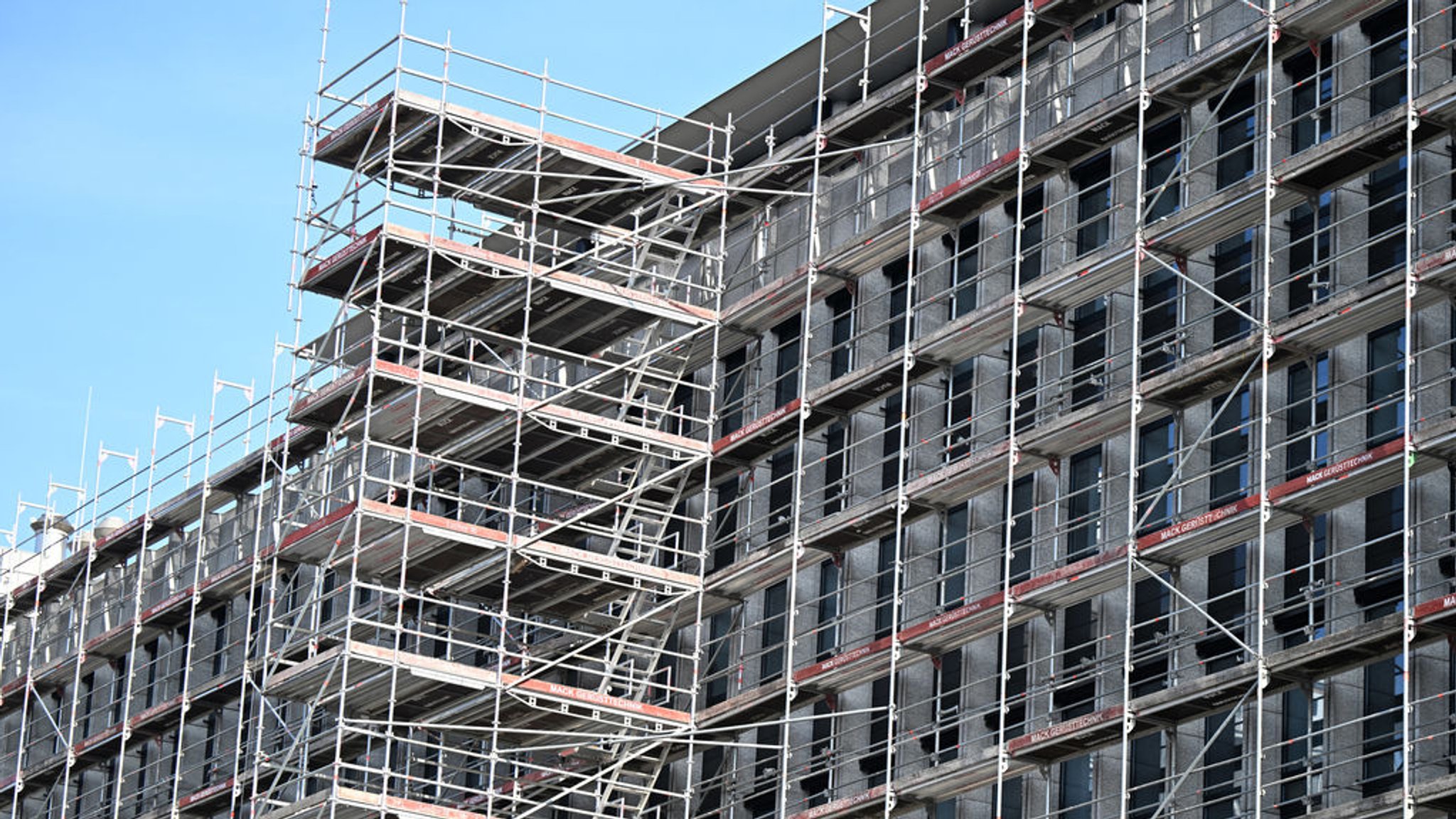 ILLUSTRATION - 29.02.2024, Baden-Württemberg, Stuttgart: Ein Gerüst steht auf einer Baustelle an einem Rohbau eines Bürogebäudes. (zu dpa: «IG BAU erhöht Druck und droht mit Streik») Foto: Bernd Weißbrod/dpa +++ dpa-Bildfunk +++