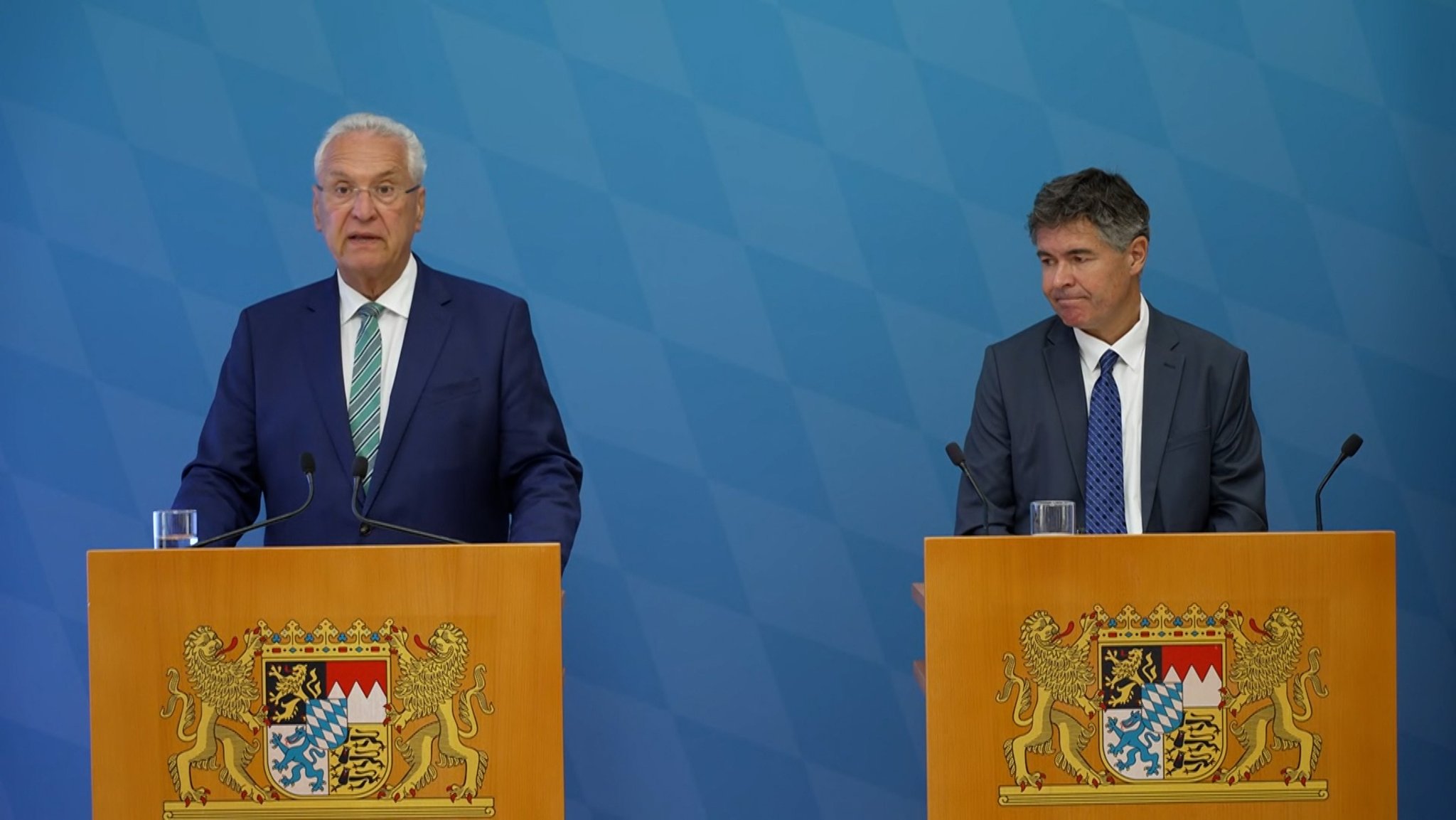 Bayerns Innenminister Herrmann und Verfassungsschutzpräsident Hauser an Rednerpulten | Bild: Bayerischer Rundfunk 2026 Bayerns Innenminister Herrmann und Verfassungsschutzpräsident Hauser an Rednerpulten