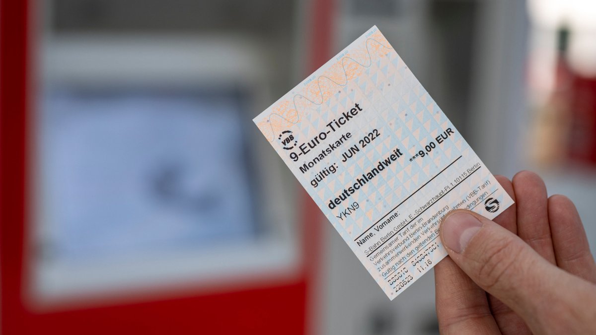 Eine Person hält ein 9-Euro-Ticket in der Hand. 