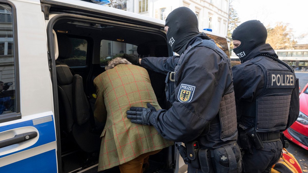 Bei einer Razzia gegen Reichsbürger führen im Dezember 2022 Polizisten in Frankfurt Heinrich XIII Prinz Reuß zu einem Polizeifahrzeug.