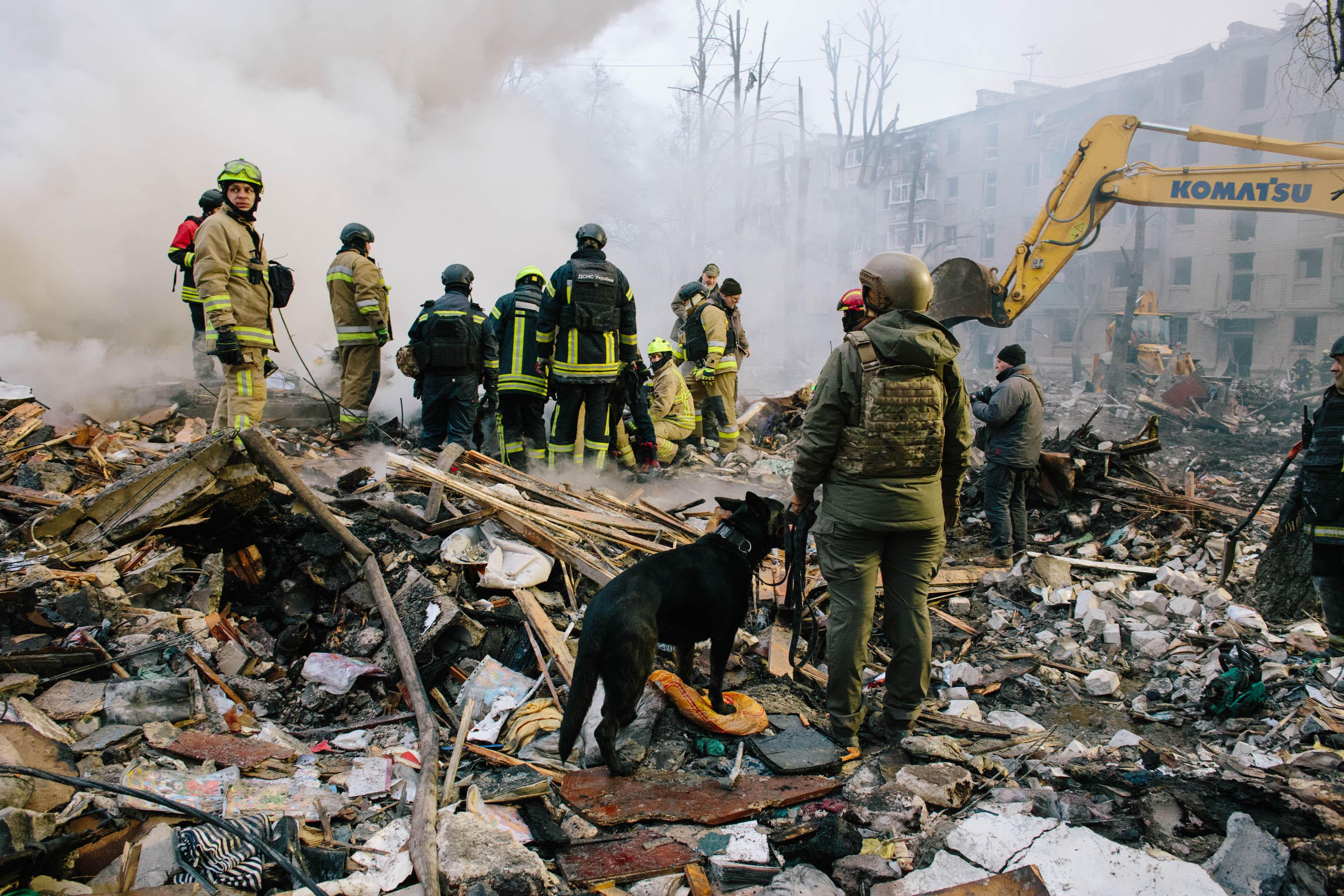 Rettungskräfte in Charkiw in den Trümmern eines Wohnhauses