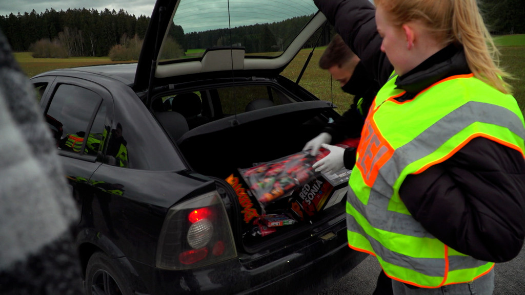 Polizeibeamten durchsuchen den Kofferraum eines Autos nach Böller.