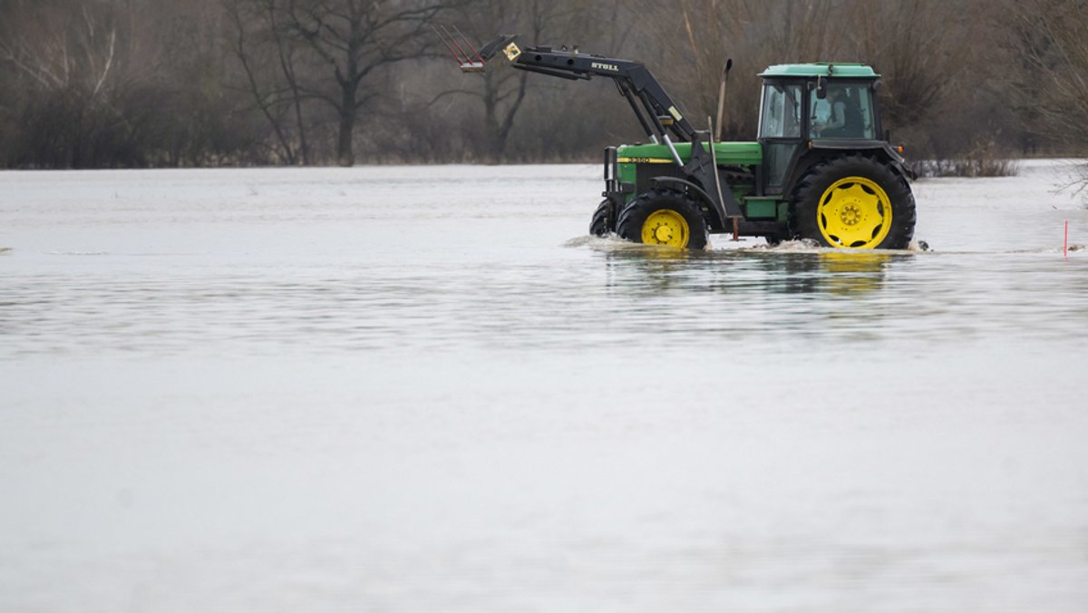 Ein Traktor fährt auf überfluteten Feldern in der Leinemasch in der südlichen Region Hannover. 