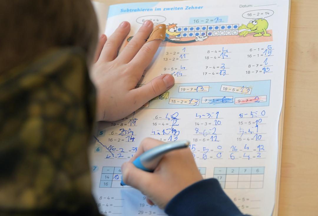 Eine Schülerin der ersten Klasse übt in einem Klassenzimmer das Subtrahieren. 