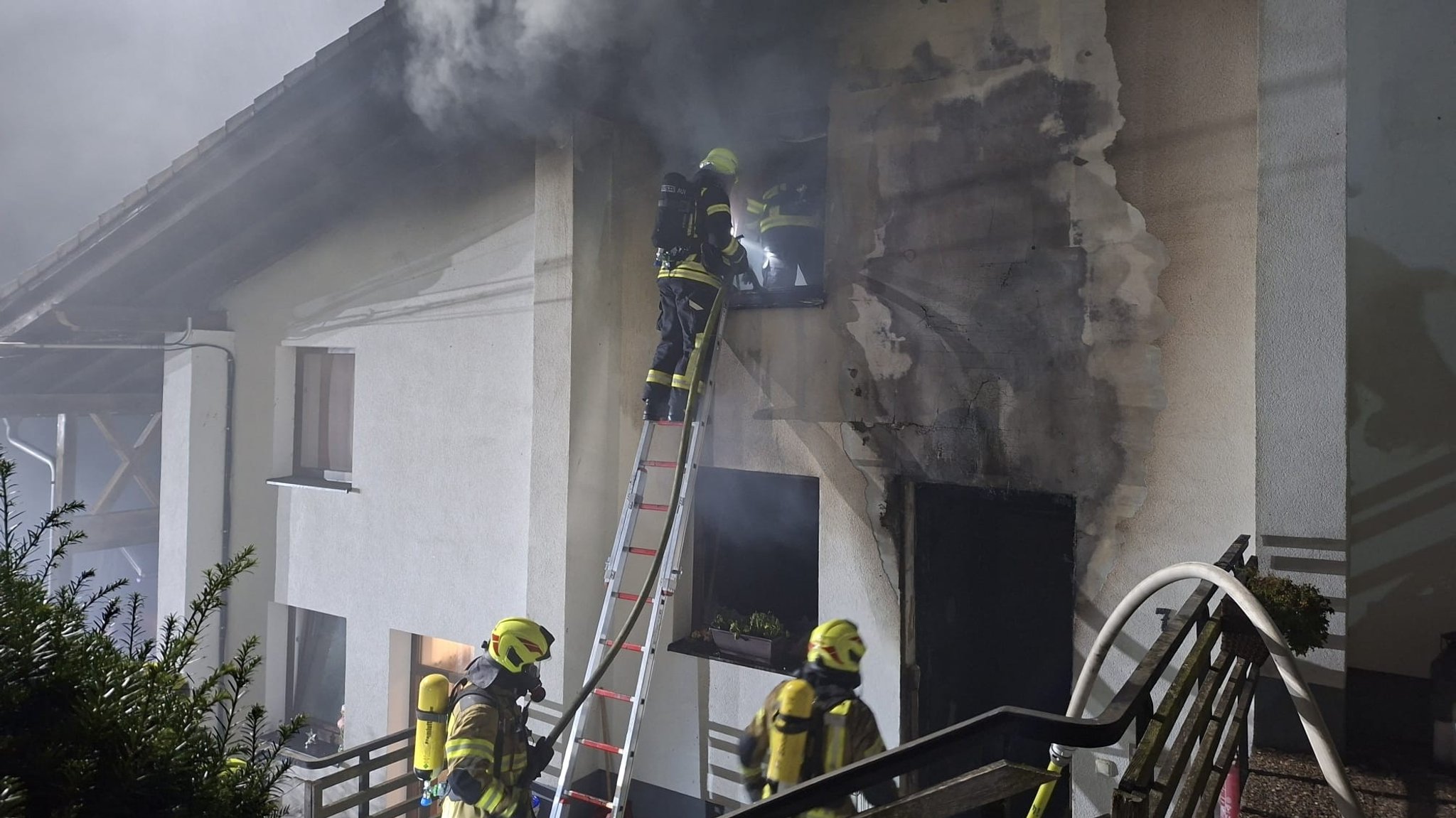Feuerwehrkräfte löschen den Brand in dem Mehrfamilienhaus in Bodenmais. 
