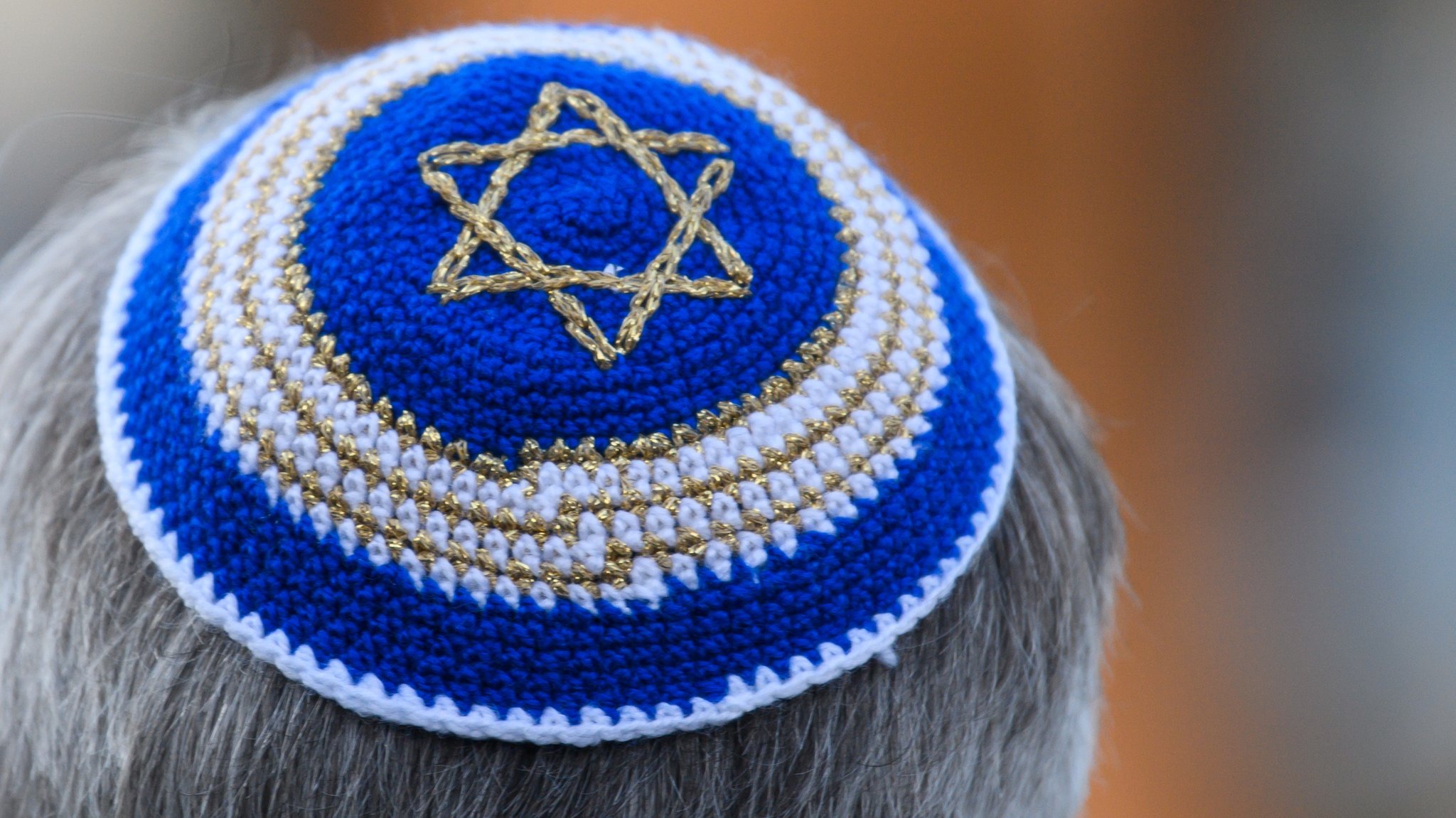 Ein Mann trägt im Rahmen einer Kranzniederlegung vor der Synagoge eine Kippa mit Judenstern - aufgenommen im November 2021. 